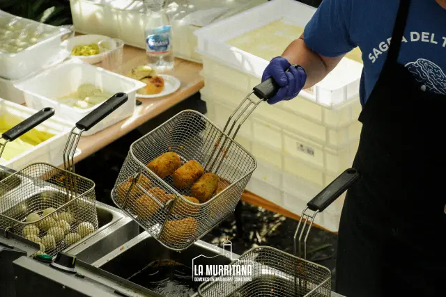 Cestello della friggitrice con supplì appena fritti durante la preparazione della sagra