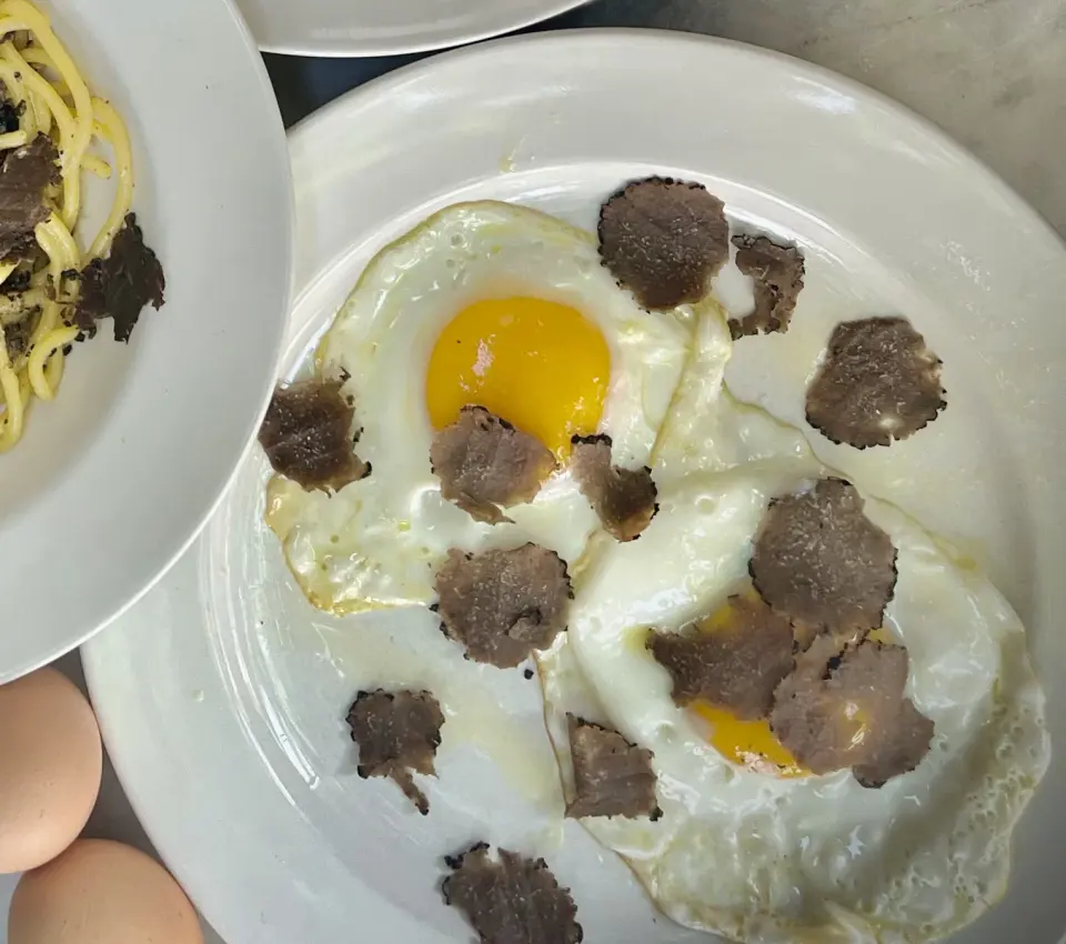 Uova al tegamino guarnite con tartufo nero fresco a lamelle