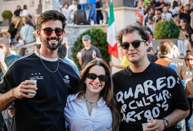 Tre amici in posa con la bandiera italiana sullo sfondo della piazza